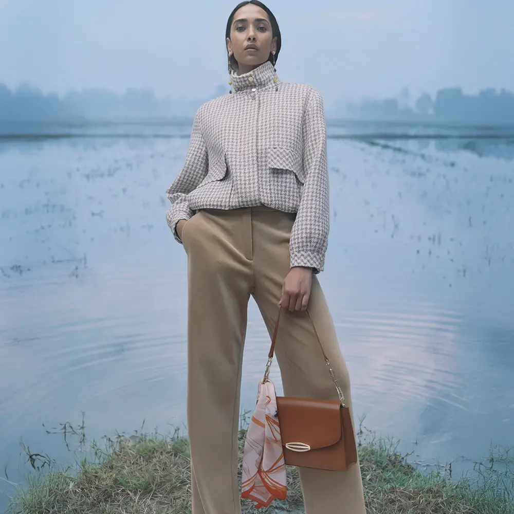Corduroy pants and houndstooth blouson with stand-up collar, paired with a mini bag and silk scarf.
