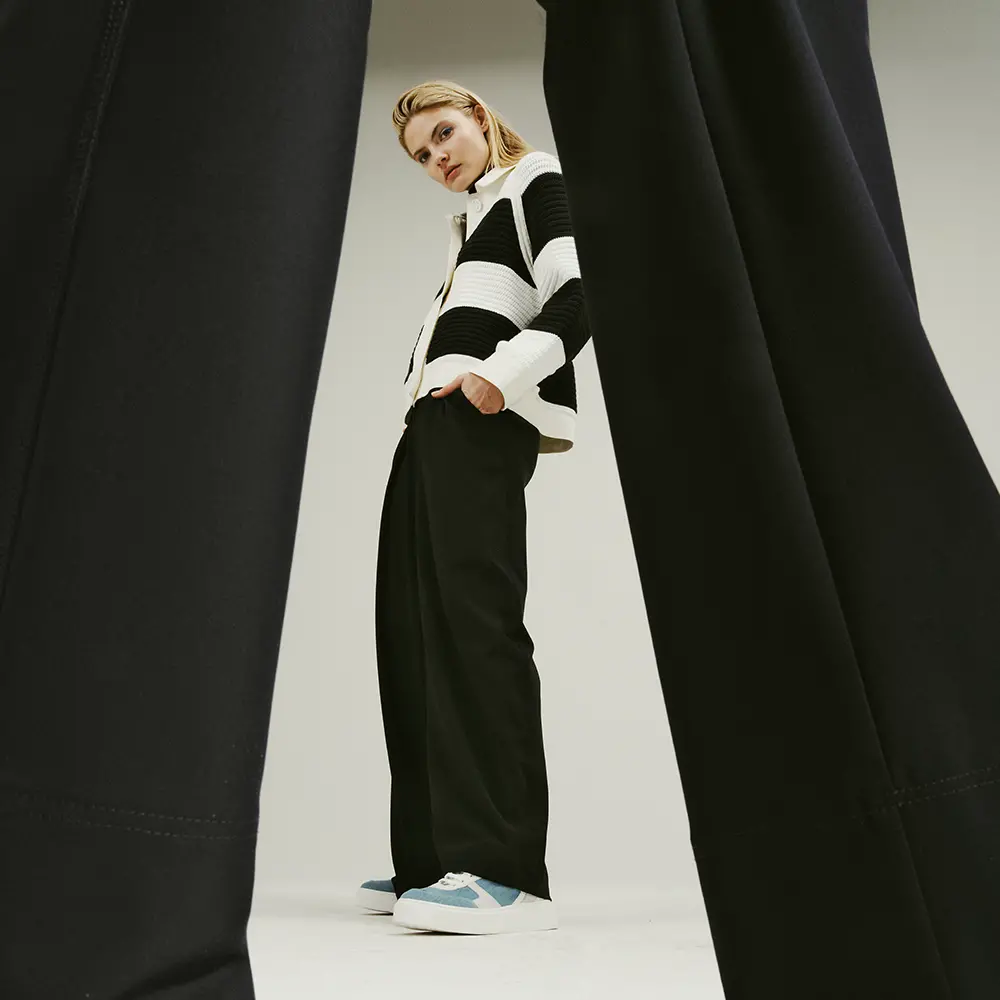 Donkerblauwe broek met sportschoenen en jasje met blokstreep