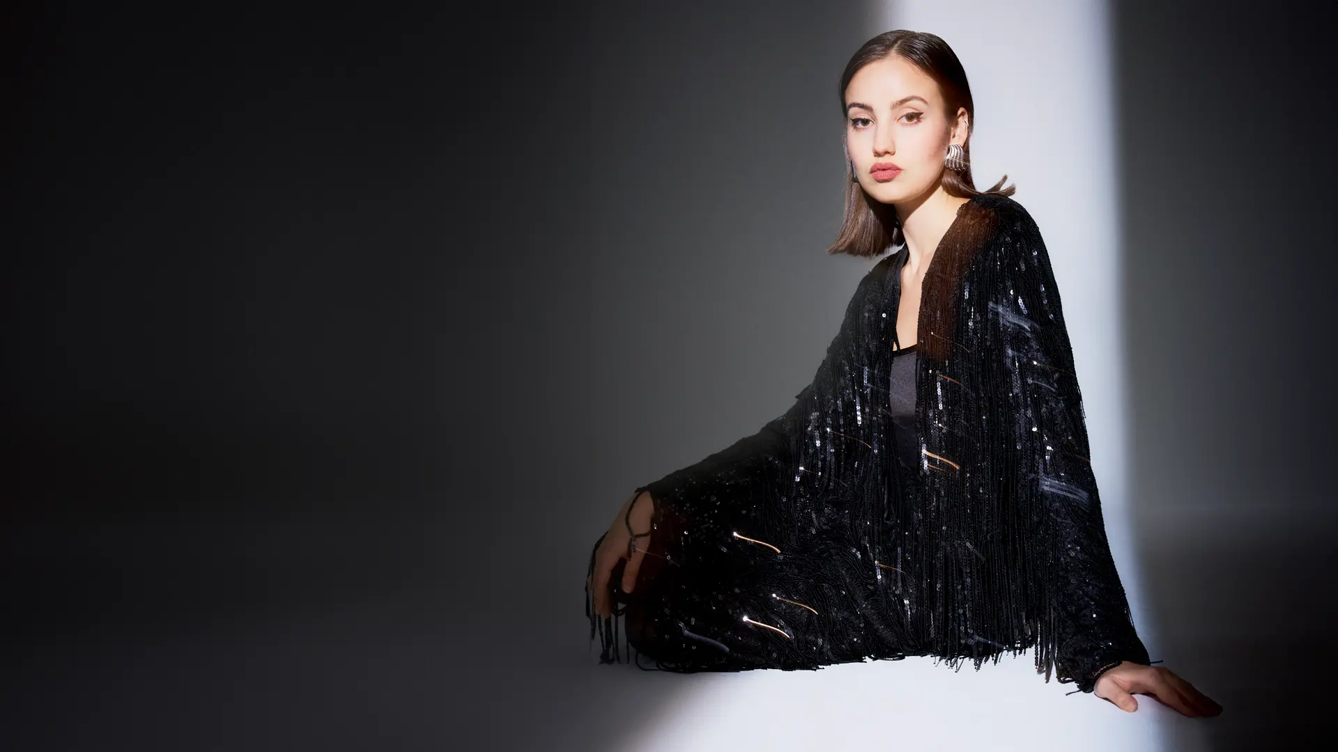 Schwarzes, glamouröses Jäckchen mit schwingenden Paillettenfransen 