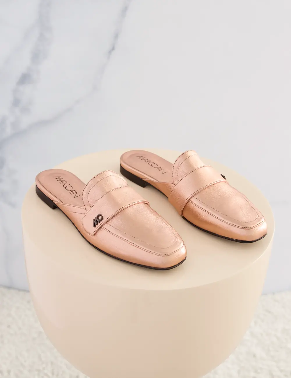 Mules plates en cuir de chèvre métallisé avec discrets rivets logo