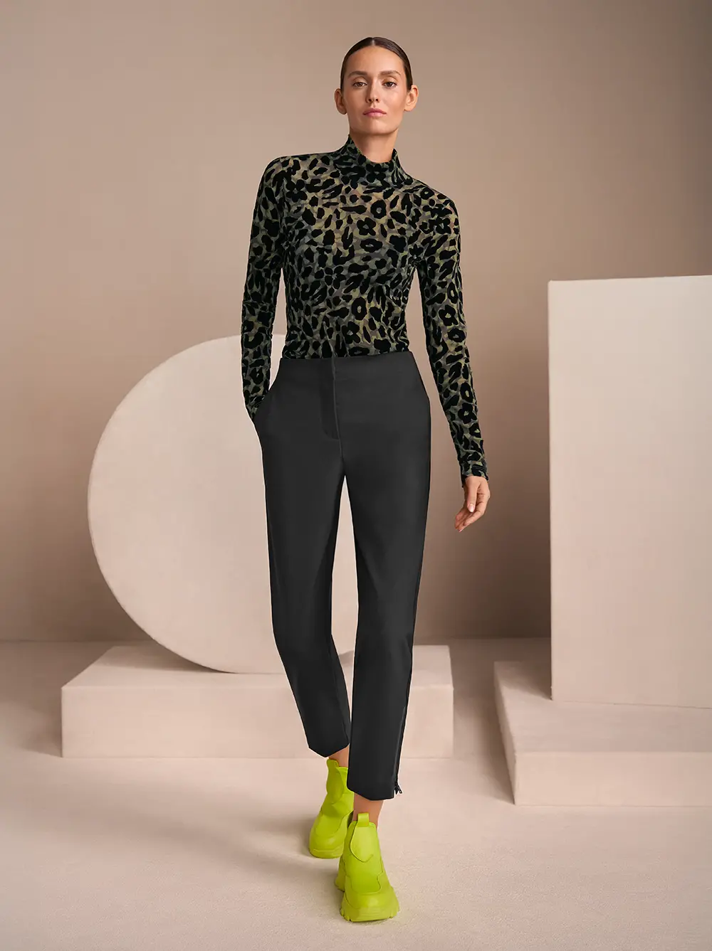 Oliv-schwarzes T-Shirt im Leoprint mit schwazer Hose und Limoncello Sneakers