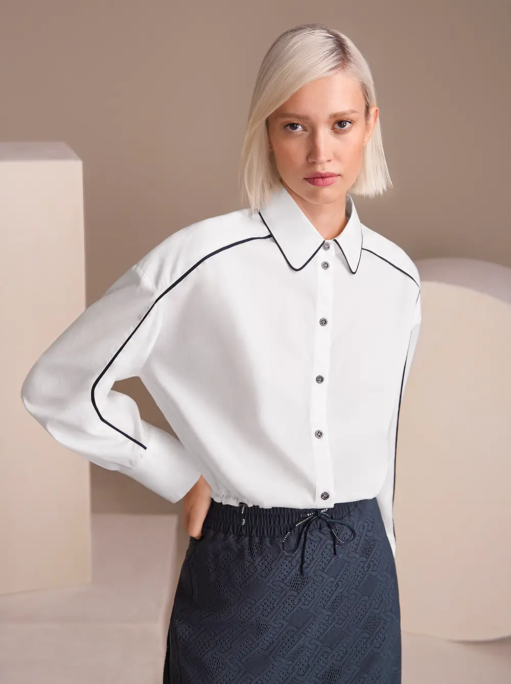 Weiße Bluse, Midi-Rock und Sneakers