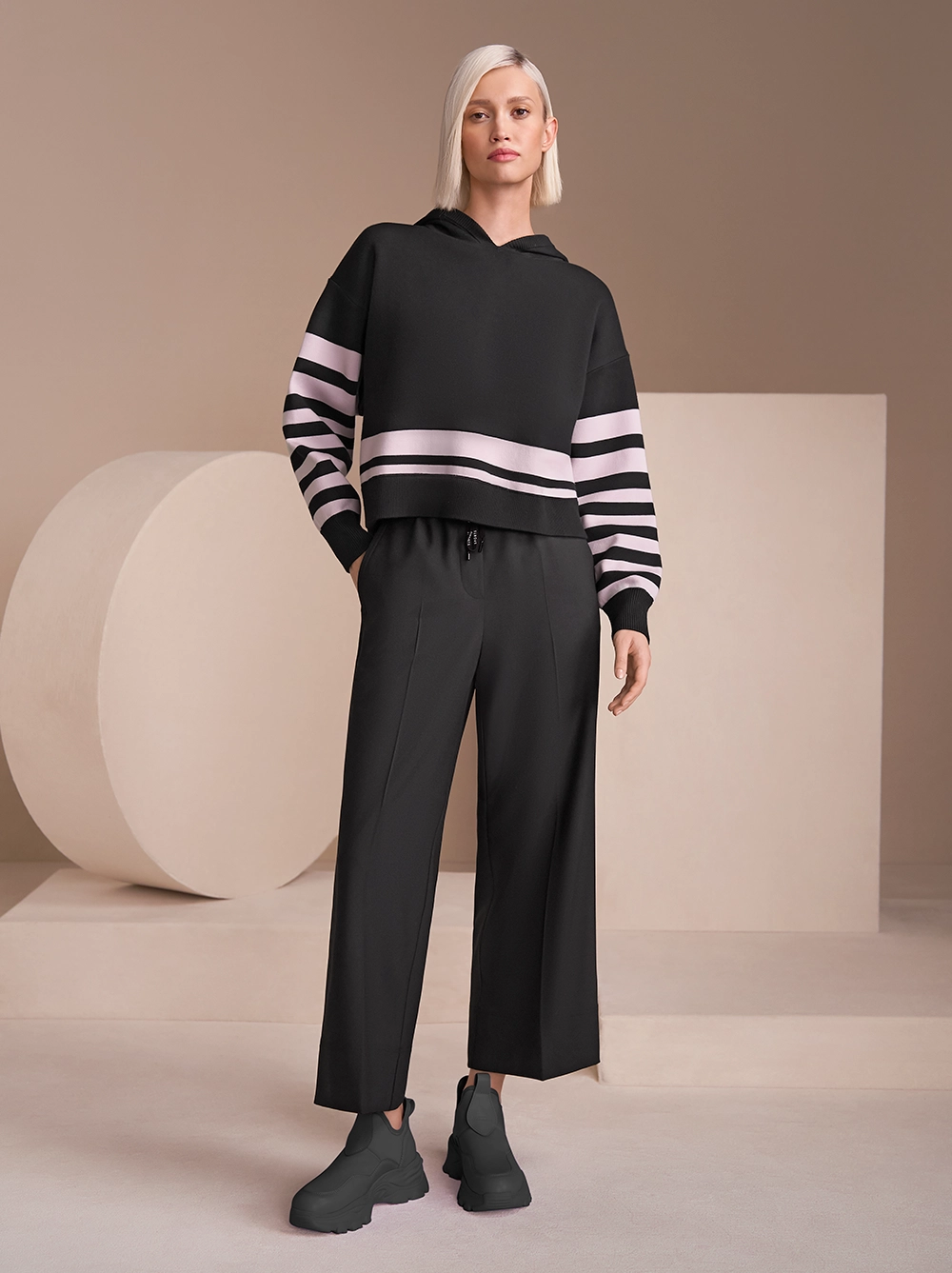 Schwarzer Sweater mit vereinzelten, rosafarbenen Streifen mit schwarzer Hose 
