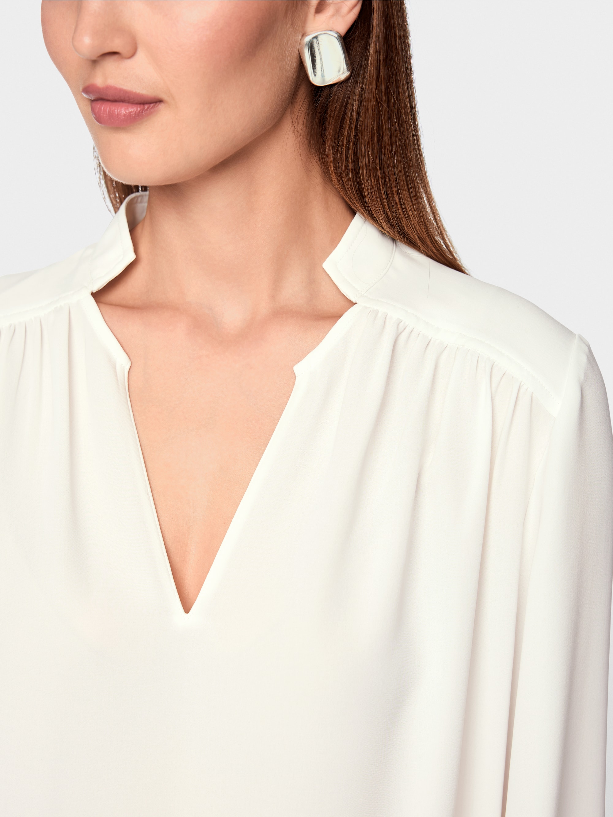 Flowing blouse with decorative button