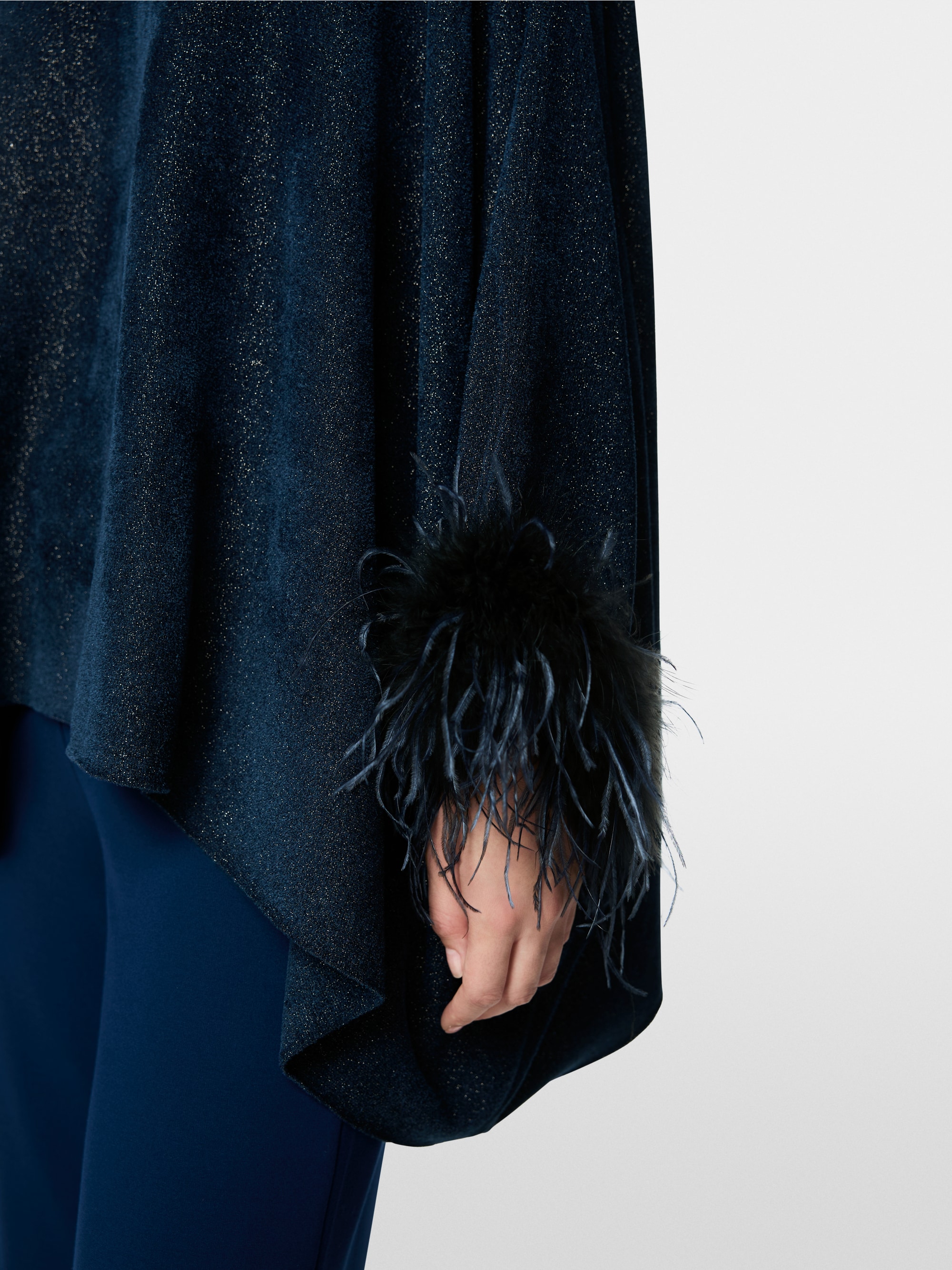 Knitted poncho with feathers