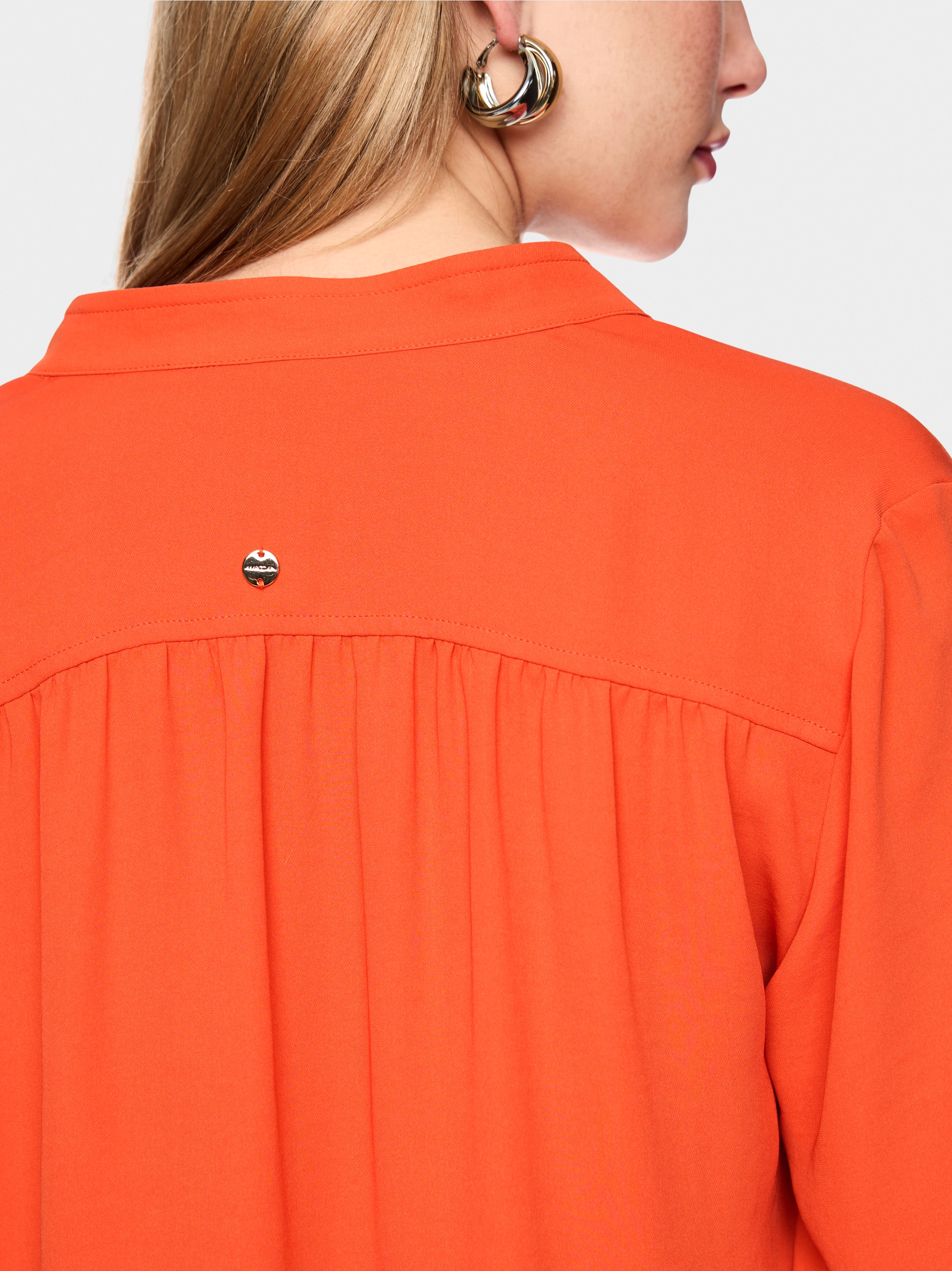 Flowing blouse with decorative button