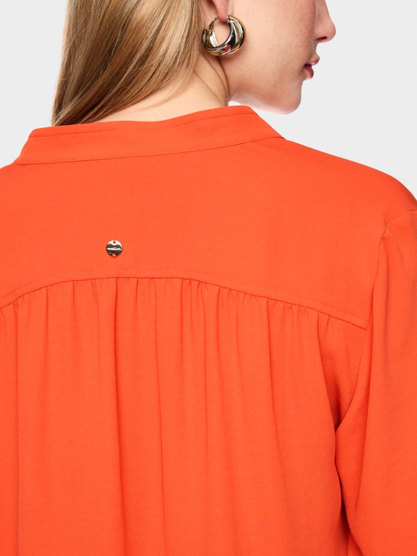 Flowing blouse with decorative button