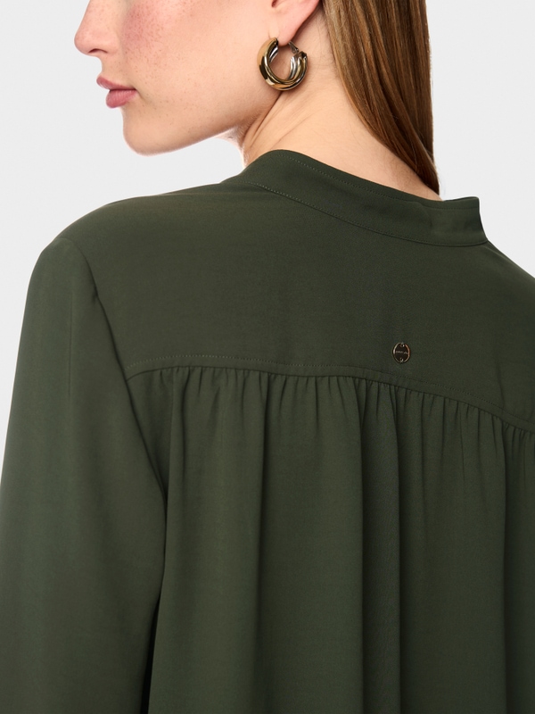 Flowing blouse with decorative button